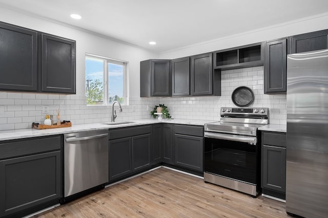 1179 Houston St S, Aransas Pass, TX 78336 - kitchen featuring stainless steel appliances, ornamental molding, tasteful backsplash, light wood-style floors, and light stone countertops