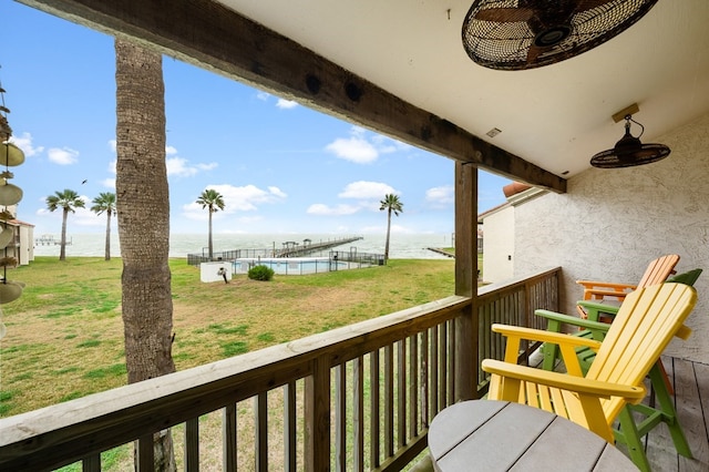 balcony with a water view and ceiling fan