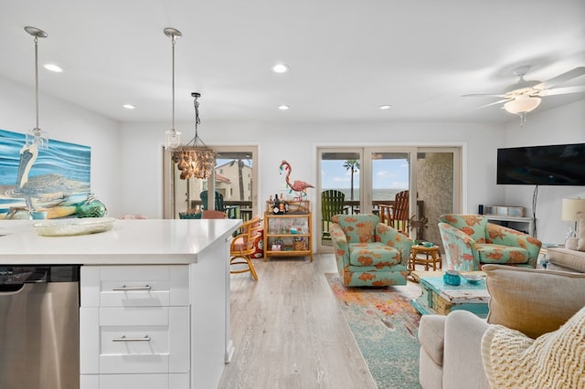 kitchen with ceiling fan, hanging light fixtures, white cabinets, stainless steel dishwasher, and light wood-type flooring