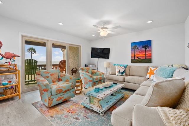 living room with ceiling fan and light hardwood / wood-style flooring