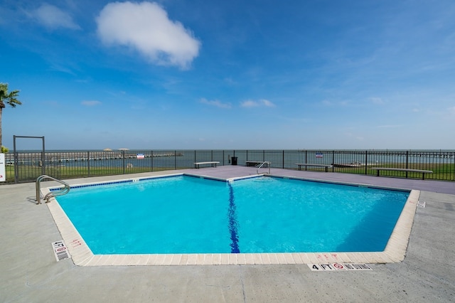 view of swimming pool with a patio and a water view