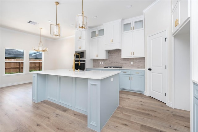 3618 Perry, Corpus Christi, TX 78410 - kitchen with a chandelier, stainless steel microwave, decorative backsplash, and light wood-style flooring