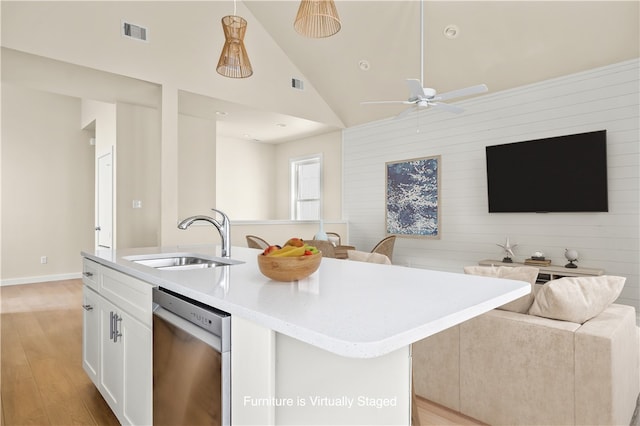 kitchen with light hardwood / wood-style floors, dishwasher, white cabinets, sink, and a kitchen island with sink