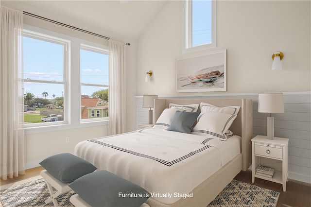 bedroom featuring hardwood / wood-style flooring and high vaulted ceiling