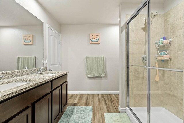 7753 Lariat Toss Dr, Corpus Christi, TX 78414 - bathroom with wood finished floors, a shower stall, double vanity, and baseboards