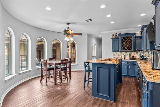 5514 King Trl, Corpus Christi, TX 78414 - kitchen featuring blue cabinets, a breakfast bar area, a center island, recessed lighting, and backsplash
