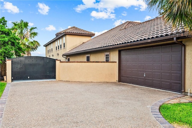 5514 King Trl, Corpus Christi, TX 78414 - view of home's exterior featuring asphalt driveway, a tile roof, stucco siding, an attached garage, and a gate