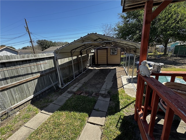 view of yard with a carport, an outdoor structure, and fence