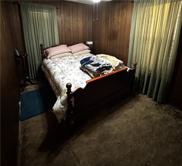 carpeted bedroom with wood walls