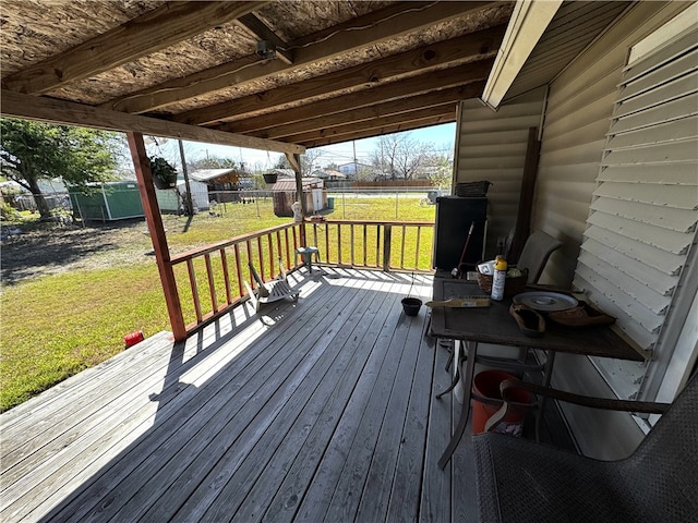 wooden terrace featuring a yard and fence