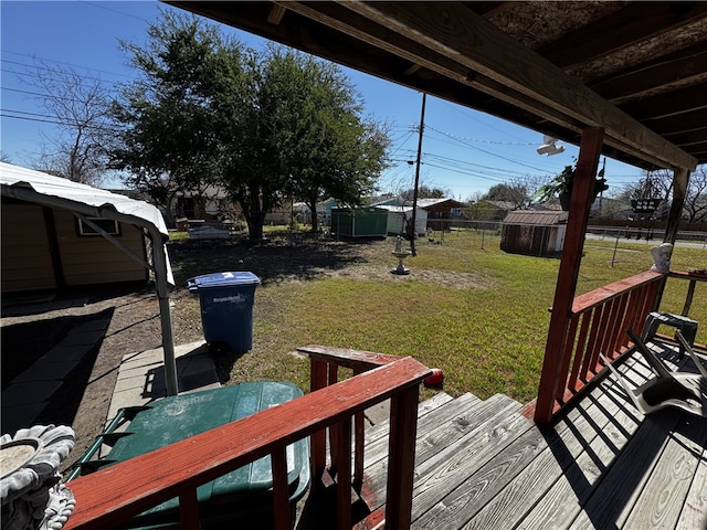 view of yard featuring an outbuilding, a deck, and a storage shed