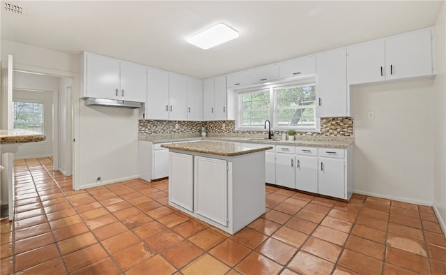 620 E 9th St, Bishop, TX 78343 - kitchen featuring visible vents, a sink, decorative backsplash, a kitchen island, and white cabinets