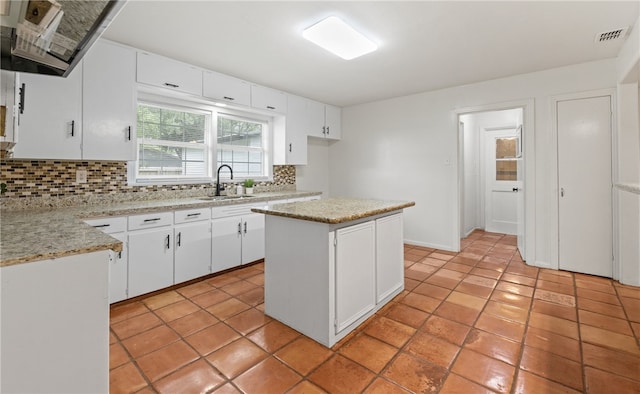 620 E 9th St, Bishop, TX 78343 - kitchen featuring a sink, visible vents, ventilation hood, decorative backsplash, and white cabinets