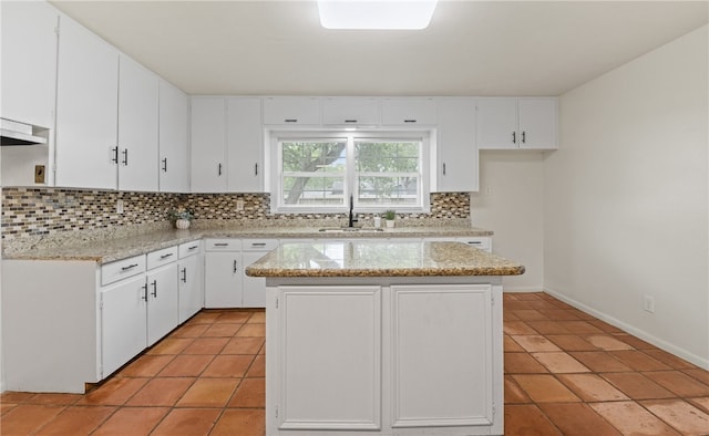 620 E 9th St, Bishop, TX 78343 - kitchen featuring light tile patterned floors, a sink, a kitchen island, backsplash, and white cabinets