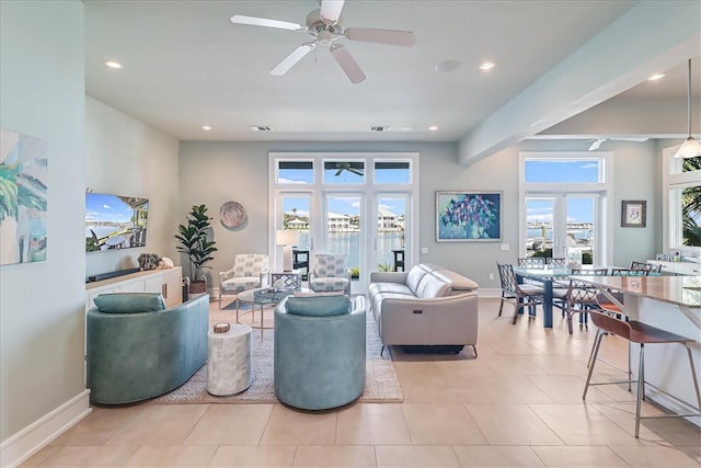 living room featuring light tile patterned flooring, a healthy amount of sunlight, and ceiling fan