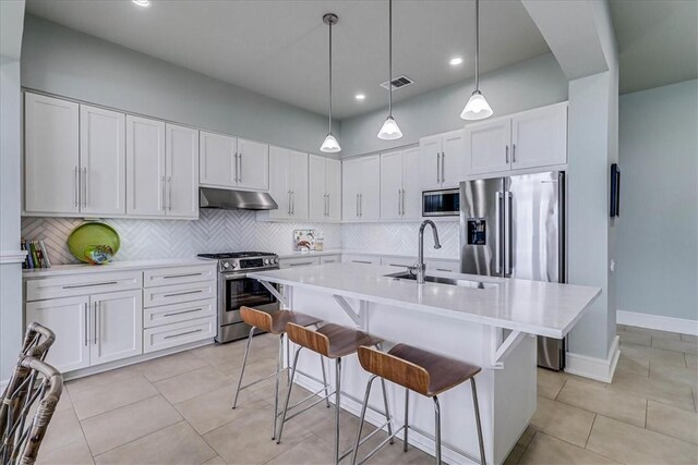 kitchen featuring range hood, white cabinetry, decorative backsplash, gas range, and light stone countertops