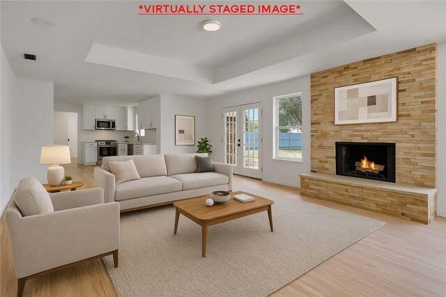 5367 Paloma Trl, Robstown, TX 78380 - living area with light wood finished floors, a tray ceiling, and a fireplace