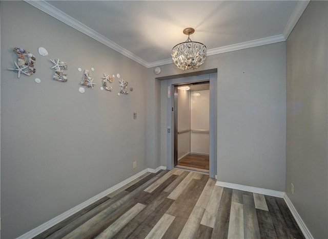 unfurnished room featuring ornamental molding, a notable chandelier, baseboards, and wood finished floors