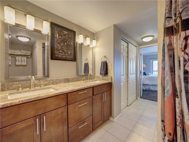 full bath featuring tile patterned flooring, double vanity, a sink, and ensuite bathroom