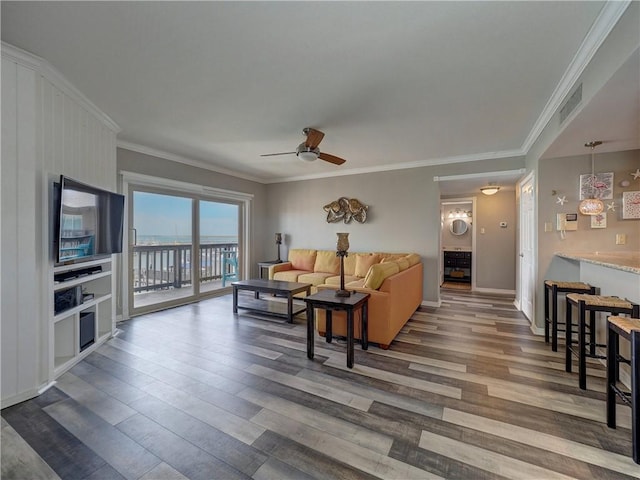 living room featuring ornamental molding, visible vents, ceiling fan, and wood finished floors