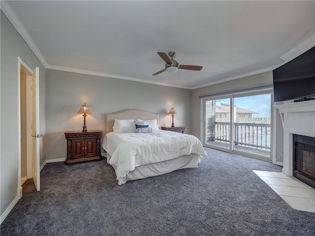 bedroom with access to exterior, crown molding, a fireplace with flush hearth, carpet flooring, and baseboards