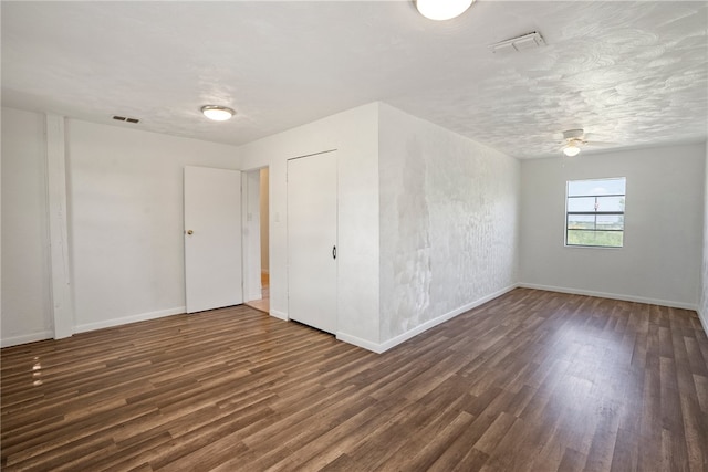 spare room featuring a textured ceiling, dark hardwood / wood-style flooring, and ceiling fan