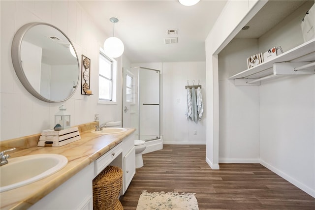 bathroom with hardwood / wood-style flooring, vanity, toilet, and walk in shower