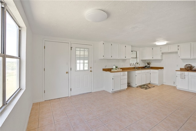 kitchen featuring plenty of natural light, white cabinetry, and a textured ceiling