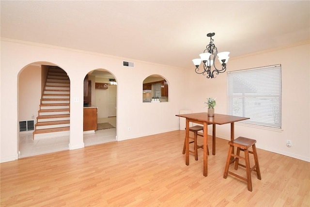 dining space with an inviting chandelier, visible vents, and light wood finished floors