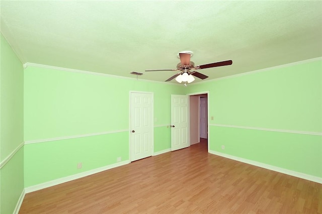 unfurnished bedroom with ornamental molding, ceiling fan, baseboards, and wood finished floors