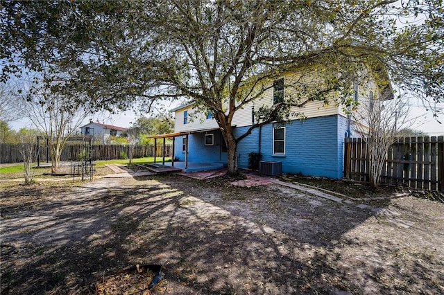 back of property with a patio, central AC, and a fenced backyard