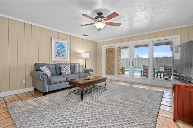 living room with ceiling fan and a textured ceiling