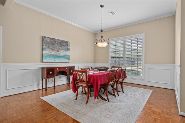 dining area featuring ornamental molding and light parquet flooring