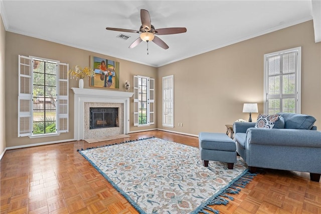 living room featuring ornamental molding, parquet floors, and ceiling fan