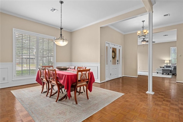 dining space with parquet floors, crown molding, and ceiling fan with notable chandelier