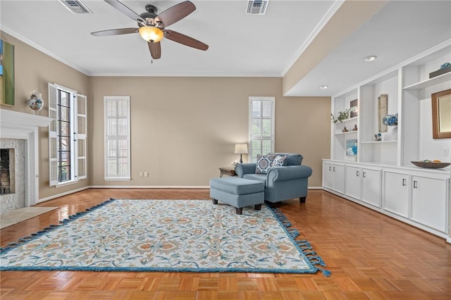 living area with built in shelves, ornamental molding, ceiling fan, a high end fireplace, and light parquet floors