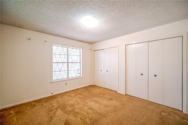 1601 Spicewood Dr, Corpus Christi, TX 78412 - unfurnished bedroom featuring two closets, carpet flooring, and a textured ceiling