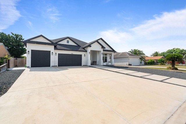modern farmhouse with a garage, fence, and concrete driveway