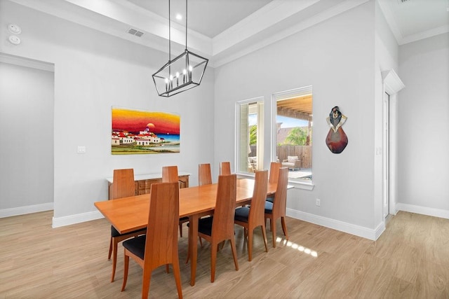 dining space featuring visible vents, baseboards, an inviting chandelier, ornamental molding, and light wood-style flooring