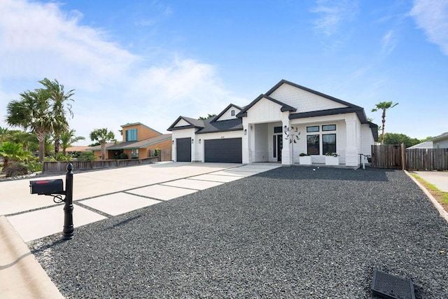 modern farmhouse featuring fence, board and batten siding, an attached garage, and concrete driveway