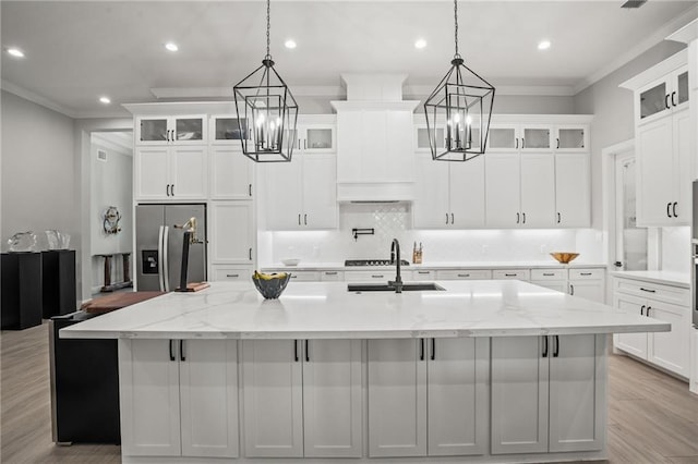 kitchen featuring crown molding, a spacious island, stainless steel fridge, recessed lighting, and a chandelier