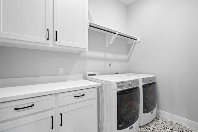 laundry area featuring baseboards, washer and clothes dryer, and cabinet space