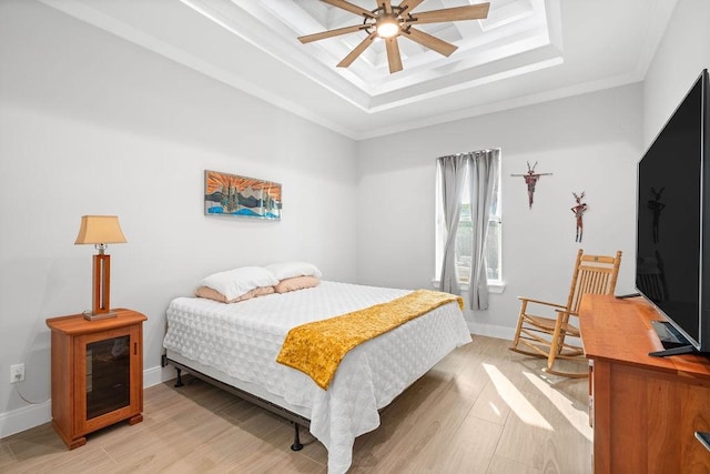 bedroom with crown molding, a raised ceiling, baseboards, and light wood finished floors