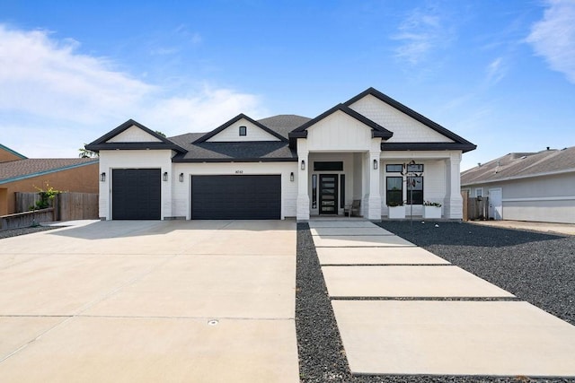 modern farmhouse with an attached garage, fence, and driveway