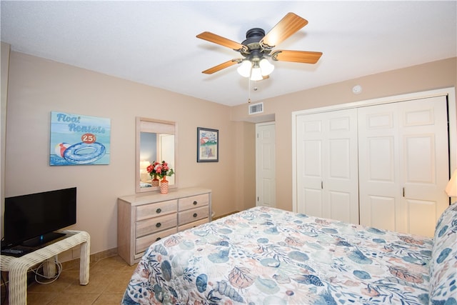 tiled bedroom featuring ceiling fan and a closet