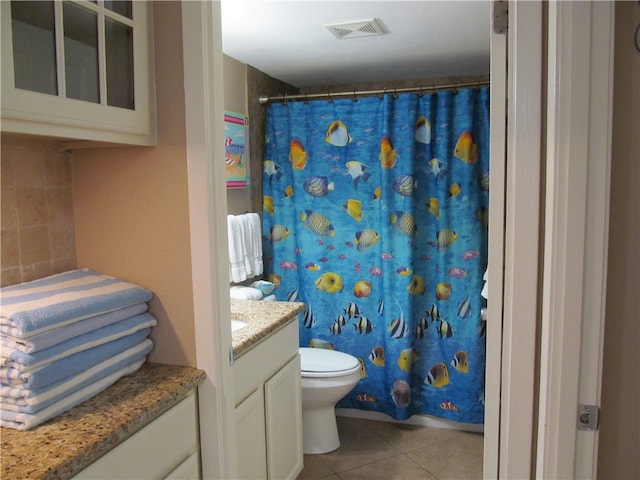 bathroom with toilet, a shower with curtain, vanity, and tile patterned floors