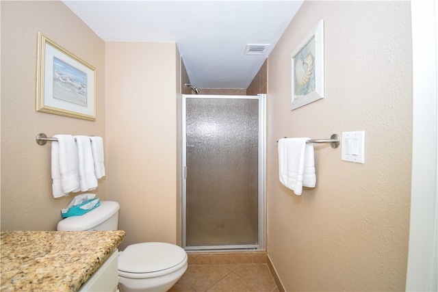 bathroom featuring toilet, an enclosed shower, vanity, and tile patterned floors