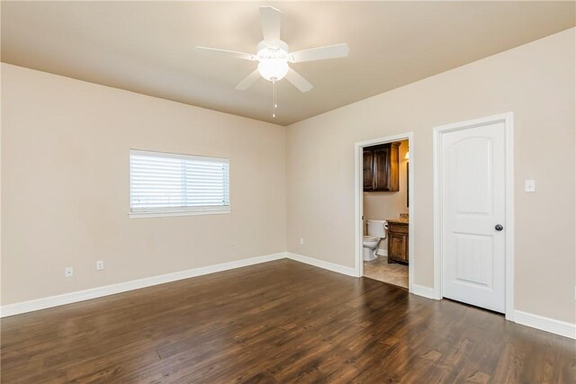 spare room with a ceiling fan, dark wood-style floors, and baseboards