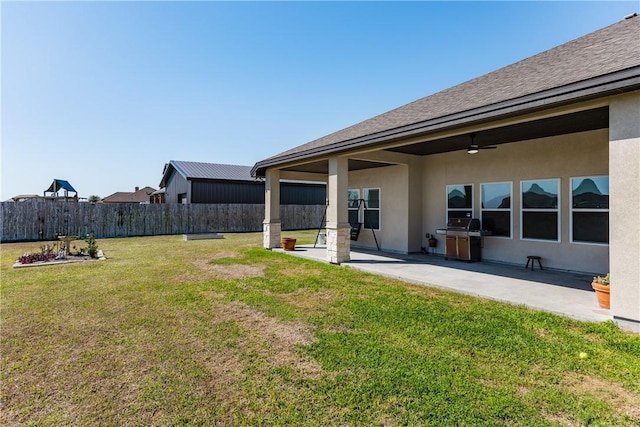 view of yard with a patio, fence, and ceiling fan