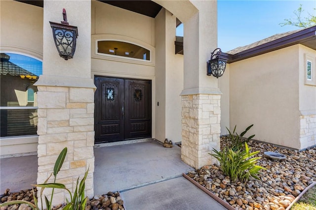 doorway to property featuring stucco siding